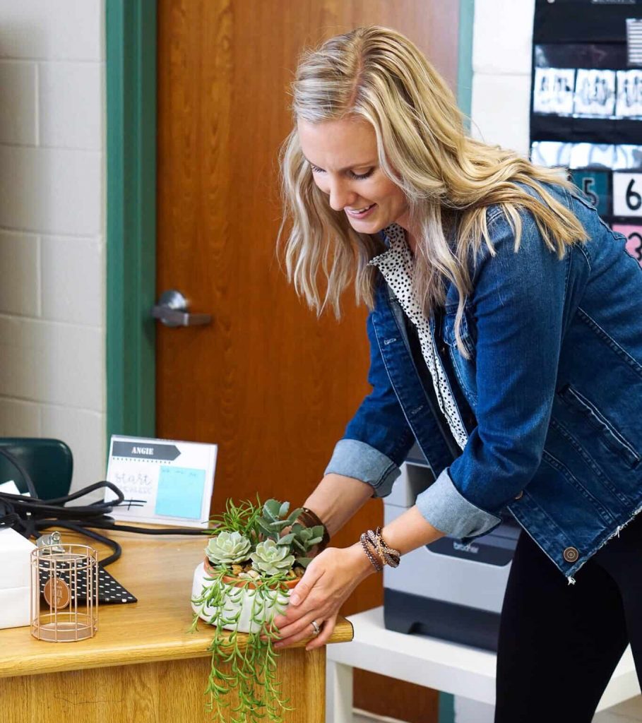 Setting a plant on Angie's desk