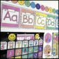 Shows multiple alphabet posters on a decorated classroom wall