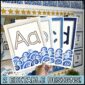Shows 4 different alphabet posters fanned out. Each alphabet poster has a blue or tan color to match the ocean classroom theme and a set of waves at the bottom of the poster