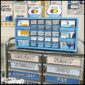 Shows a close up of the teacher toolbox labels. The toolbox is spray painted blue and all of the labels are in a blue and tan color scheme to match the ocean classroom theme