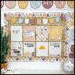 Shows the posters set up on a bulletin board in a real classroom. On top of the bulletin board are alphabet posters