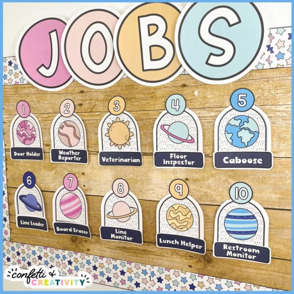 Space Classroom Jobs 4 Shows a side angle of the classroom jobs set up on a bulletin board. The items have the space classroom theme color scheme