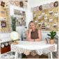 Shows Megan sitting in a corner of the Neutral Classroom Theme. Features the birthday board and a white desk Megan is sitting at